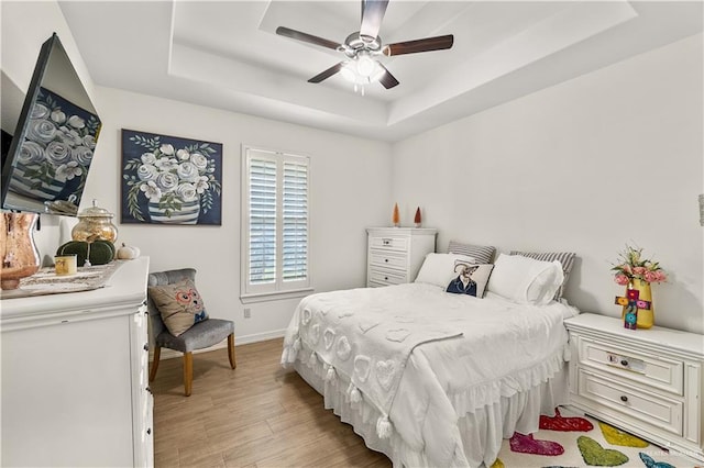 16593 W Mccullar Ct, Harlingen, TX 78552 - bedroom with a tray ceiling, light wood-style floors, baseboards, and a ceiling fan