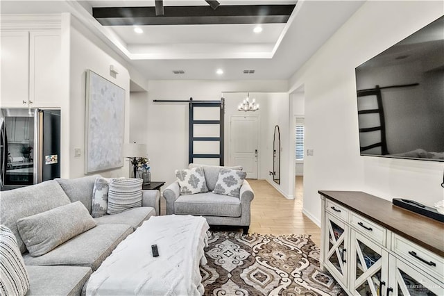16593 W Mccullar Ct, Harlingen, TX 78552 - living area featuring a barn door, light wood-style flooring, a chandelier, a tray ceiling, and recessed lighting