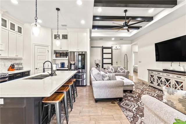 16593 W Mccullar Ct, Harlingen, TX 78552 - living area featuring ceiling fan, light wood finished floors, recessed lighting, a barn door, and beam ceiling