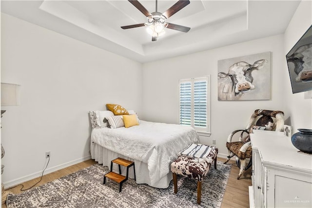 16593 W Mccullar Ct, Harlingen, TX 78552 - bedroom with a raised ceiling, light wood-type flooring, baseboards, and ceiling fan