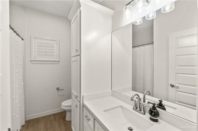 16593 W Mccullar Ct, Harlingen, TX 78552 - full bathroom with vanity, wood finished floors, toilet, and baseboards