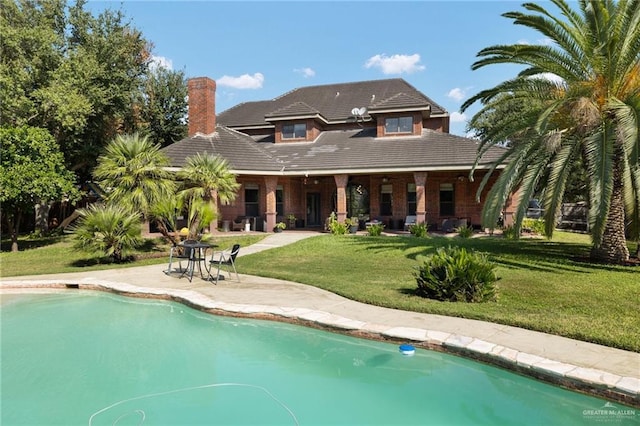 back of house featuring a lawn and a patio area