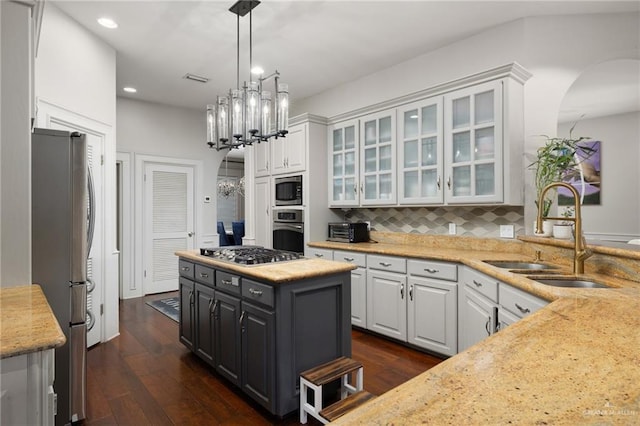 kitchen with light stone counters, sink, white cabinets, and appliances with stainless steel finishes