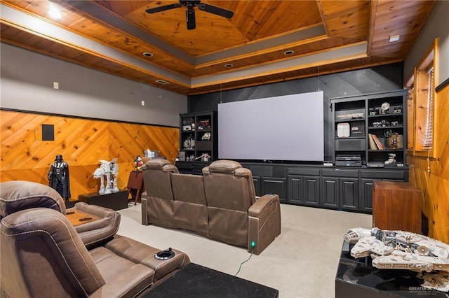 home theater room featuring wood walls, wooden ceiling, a tray ceiling, carpet floors, and ceiling fan