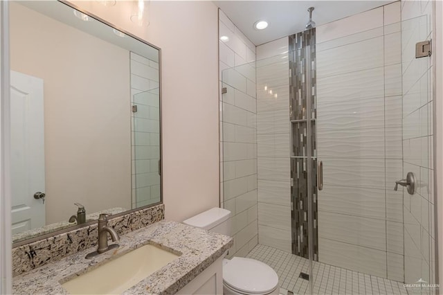 bathroom featuring vanity, toilet, and a shower with door