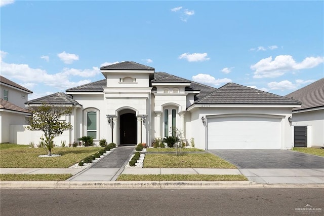 view of front of house with a front lawn, stucco siding, aphalt driveway, and a garage