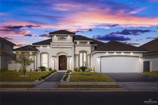 mediterranean / spanish home featuring stucco siding, driveway, and a garage