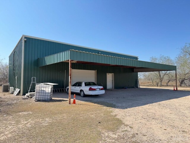 view of outbuilding with a garage and central AC unit