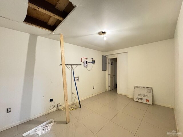 basement featuring electric panel and tile patterned flooring