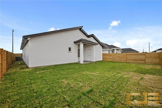 rear view of house with a lawn and central AC unit