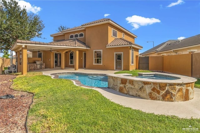 back of property featuring an outdoor kitchen, a pool with hot tub, ceiling fan, a yard, and a patio area