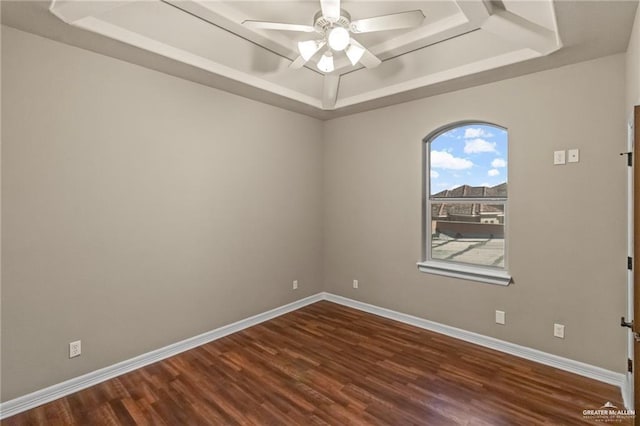 unfurnished room with dark hardwood / wood-style flooring, ceiling fan, and a raised ceiling