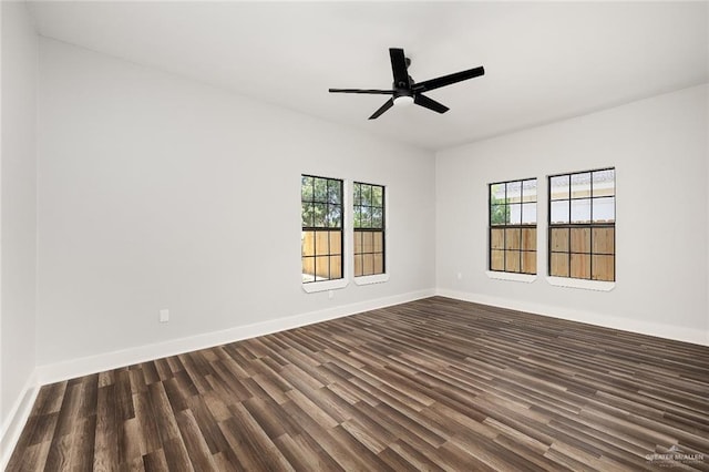 spare room featuring ceiling fan, a healthy amount of sunlight, and dark hardwood / wood-style floors