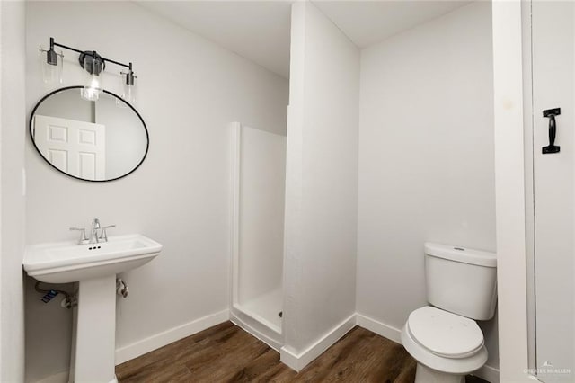 bathroom with hardwood / wood-style floors, sink, toilet, and a shower