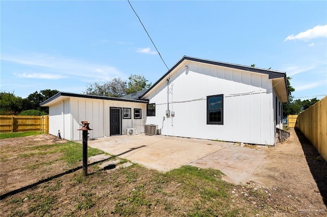 back of property with central AC unit and a patio area