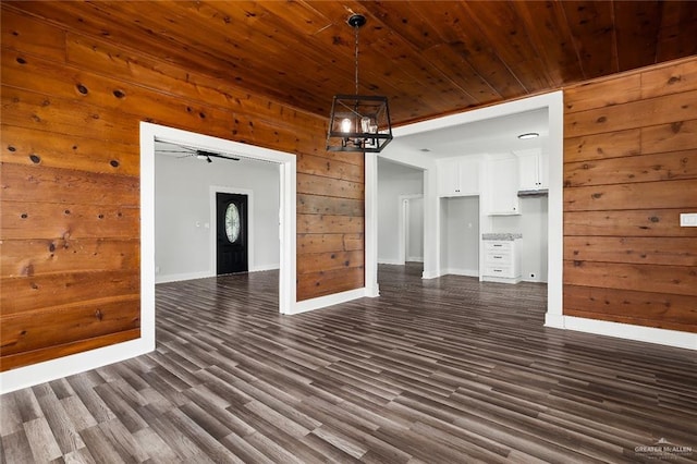 interior space featuring wooden walls, wooden ceiling, ceiling fan, and dark wood-type flooring