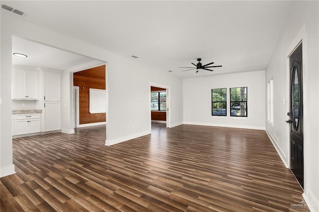 unfurnished living room with ceiling fan and dark wood-type flooring