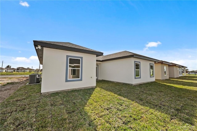 rear view of property featuring a yard and cooling unit