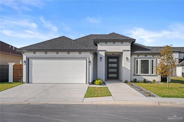 prairie-style house with a garage and a front lawn