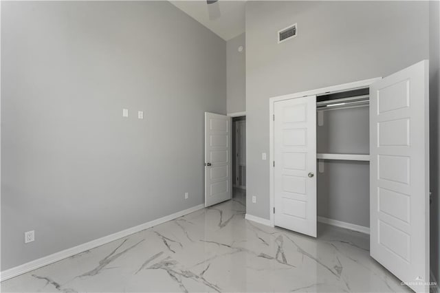 unfurnished bedroom with ceiling fan, a closet, and high vaulted ceiling