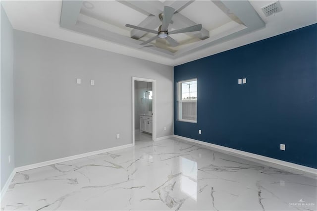 unfurnished bedroom with a raised ceiling, ceiling fan, ensuite bathroom, and coffered ceiling