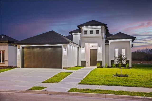 view of front of property featuring a garage and a yard