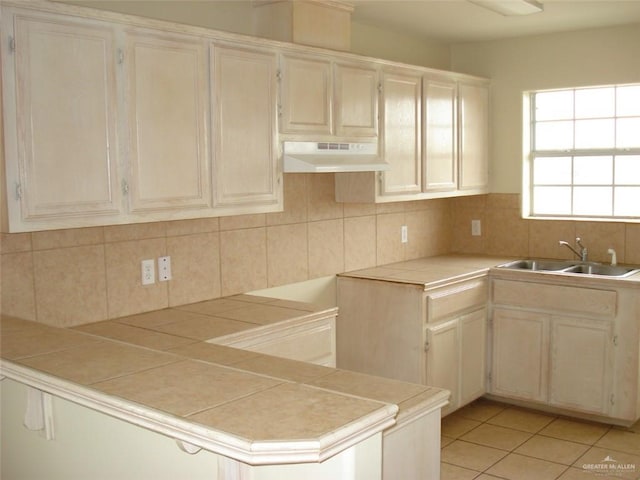 719 W Sherryl Ave, Pharr, TX 78577 - kitchen featuring under cabinet range hood, a sink, backsplash, and light tile patterned floors
