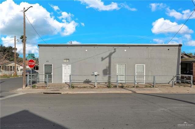 rear view of property with fence and stucco siding