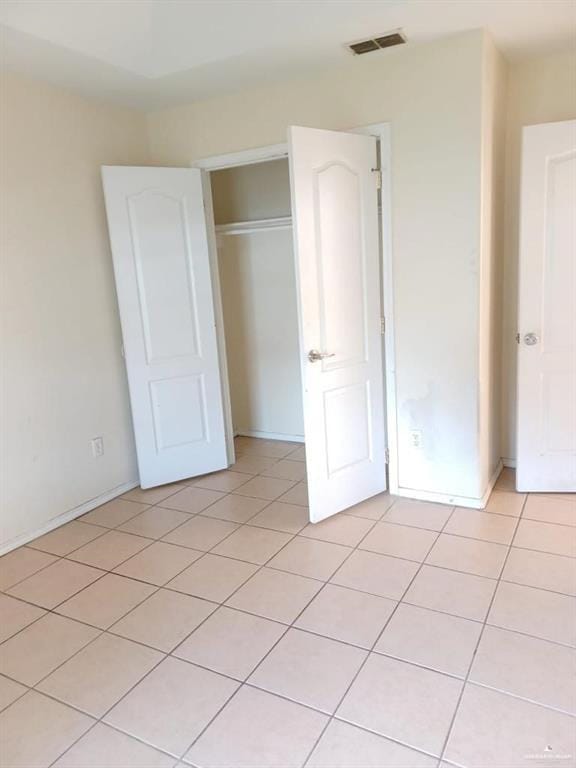 unfurnished bedroom with a closet and light tile patterned flooring