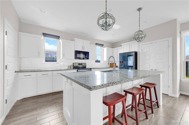 5237 Lost Creek Ln, Mcallen, TX 78504 - kitchen featuring black appliances, a chandelier, decorative backsplash, white cabinets, and recessed lighting