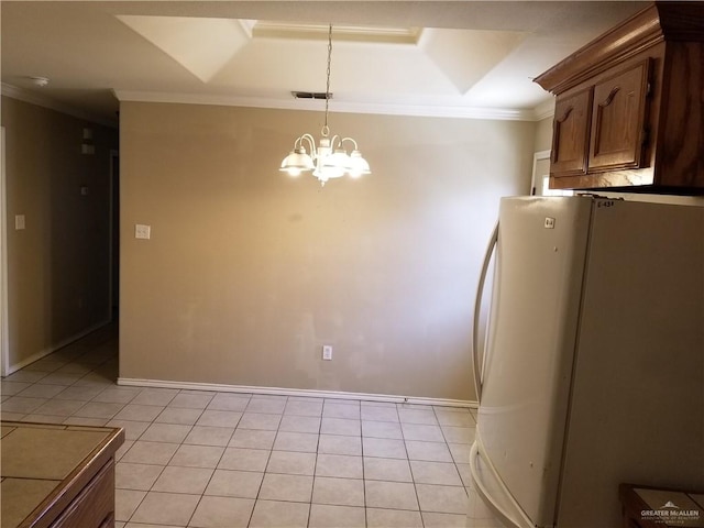 kitchen with an inviting chandelier, tile countertops, white fridge, light tile patterned flooring, and ornamental molding