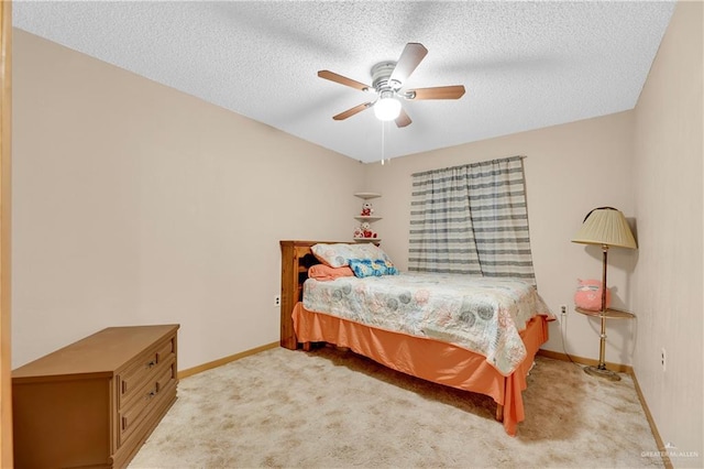 bedroom with ceiling fan, light carpet, and a textured ceiling