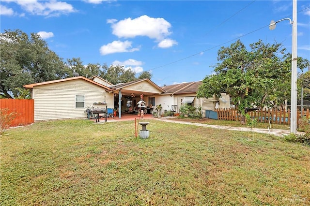 rear view of house with a lawn and a patio area