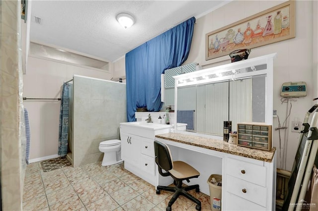 bathroom with vanity, a shower with shower curtain, a textured ceiling, and toilet