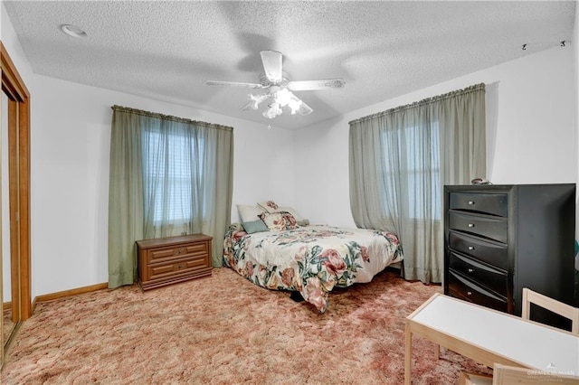 carpeted bedroom featuring ceiling fan and a textured ceiling