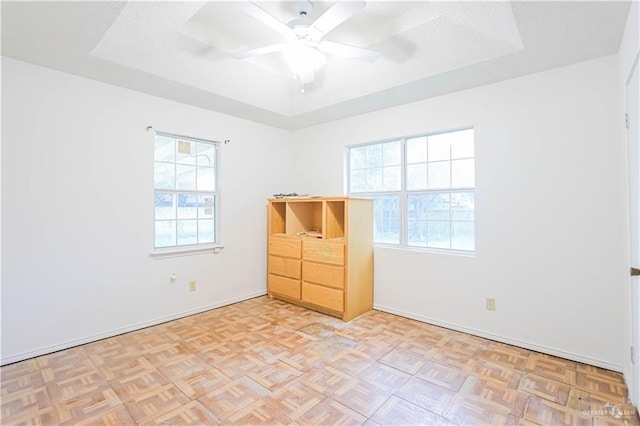 unfurnished room featuring light parquet floors, a wealth of natural light, and ceiling fan