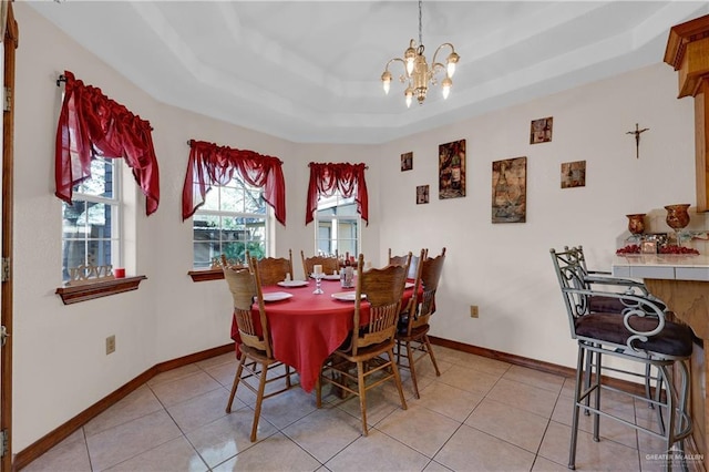 dining room with a tray ceiling, baseboards, an inviting chandelier, and light tile patterned flooring