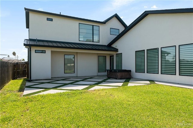 1426 Kalob Cir, Harlingen, TX 78552 - rear view of property featuring a hot tub, a standing seam roof, a patio, stucco siding, and metal roof