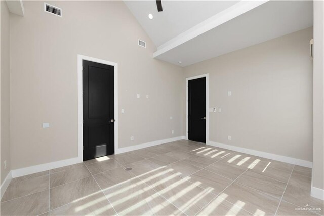 1426 Kalob Cir, Harlingen, TX 78552 - empty room featuring baseboards, light tile patterned floors, and high vaulted ceiling
