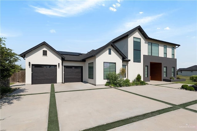 1426 Kalob Cir, Harlingen, TX 78552 - view of front of house featuring concrete driveway, stucco siding, a garage, solar panels, and fence