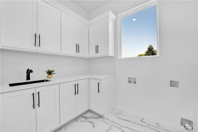 washroom featuring a sink, cabinet space, hookup for a washing machine, baseboards, and marble finish floor