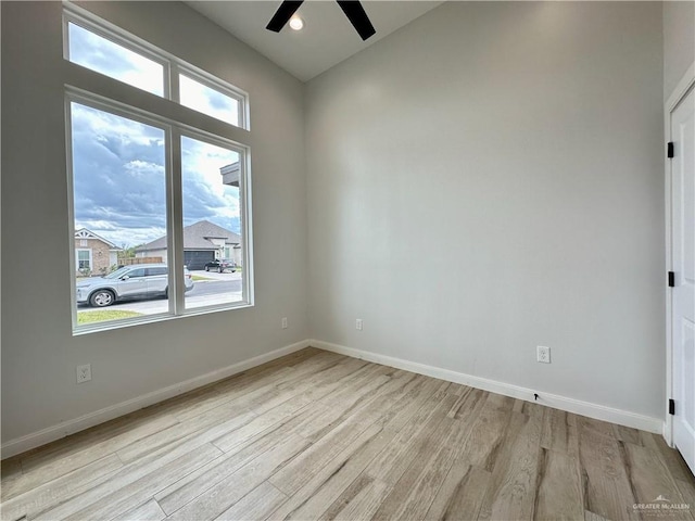 unfurnished room featuring ceiling fan, plenty of natural light, and light wood-type flooring