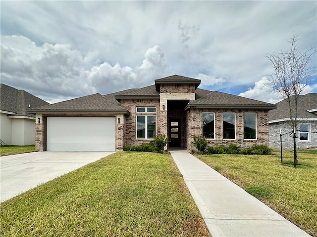 prairie-style home featuring a front yard and a garage