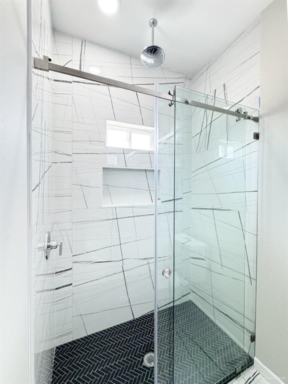 bathroom featuring a shower with door