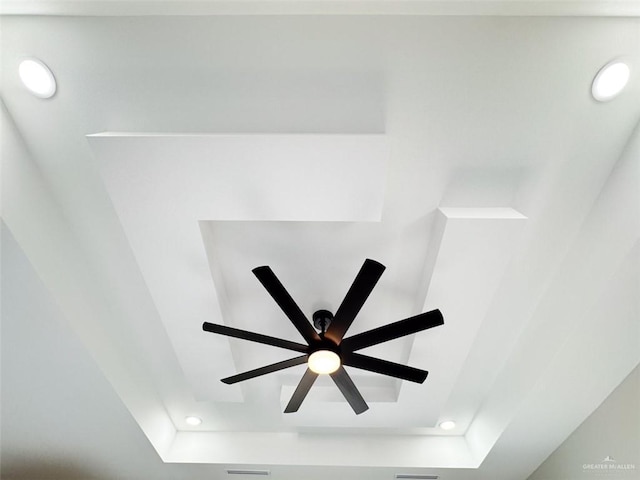 details featuring ceiling fan and a tray ceiling