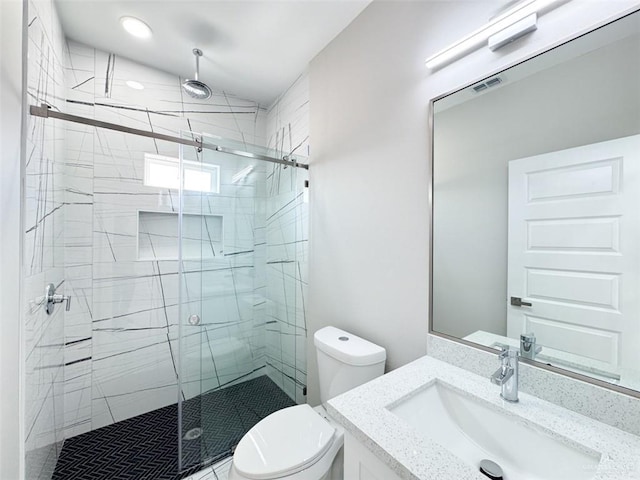 bathroom with vanity, toilet, and a shower with shower door