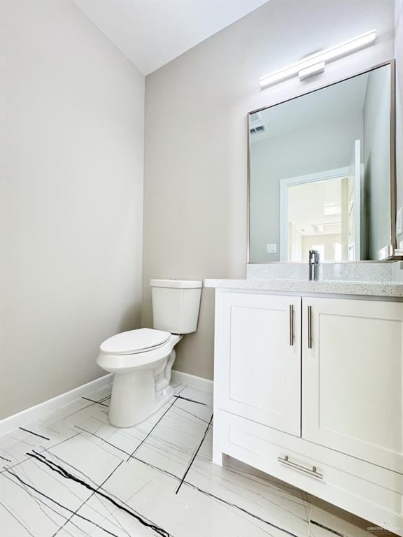 bathroom featuring vanity and toilet