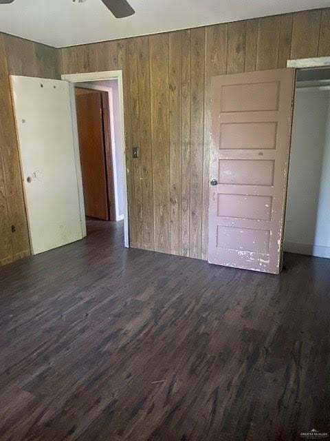 223 W Schunior St, Edinburg, TX 78541 - spare room featuring wooden walls, a ceiling fan, and dark wood finished floors