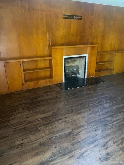 223 W Schunior St, Edinburg, TX 78541 - unfurnished living room with dark wood finished floors, wood walls, and a tile fireplace