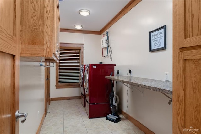 clothes washing area with light tile patterned floors, washing machine and dryer, and ornamental molding